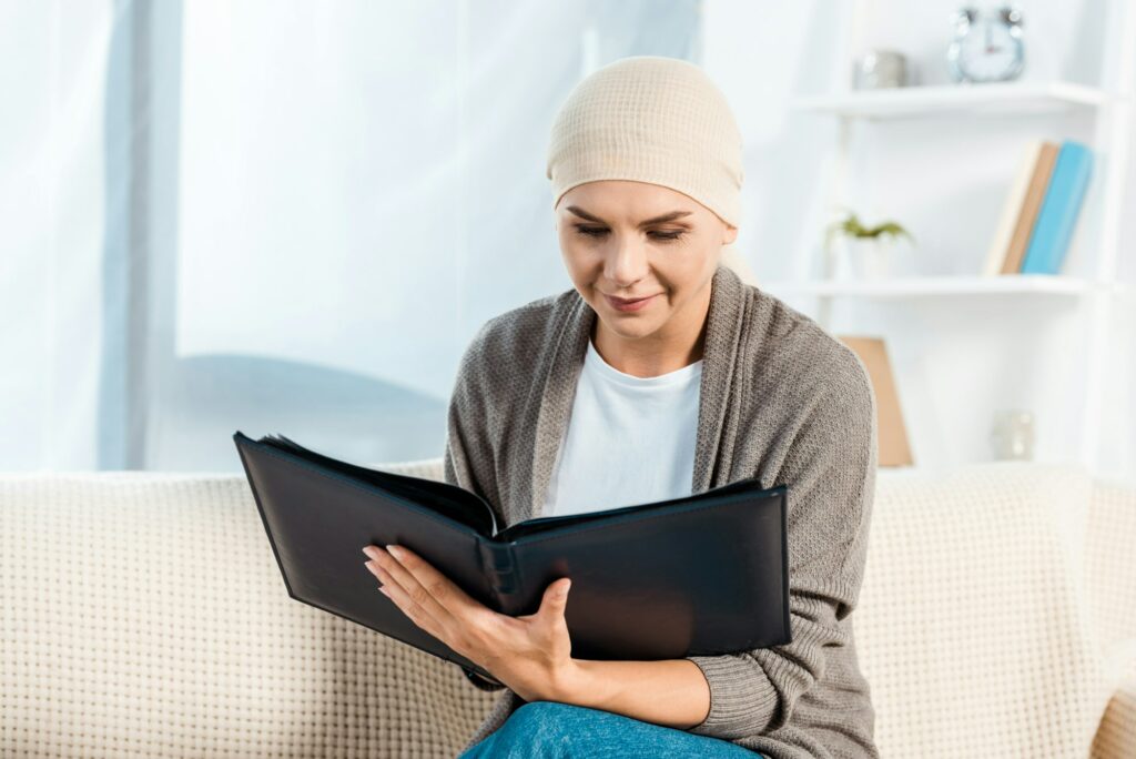 sick woman with head scarf holding photo album